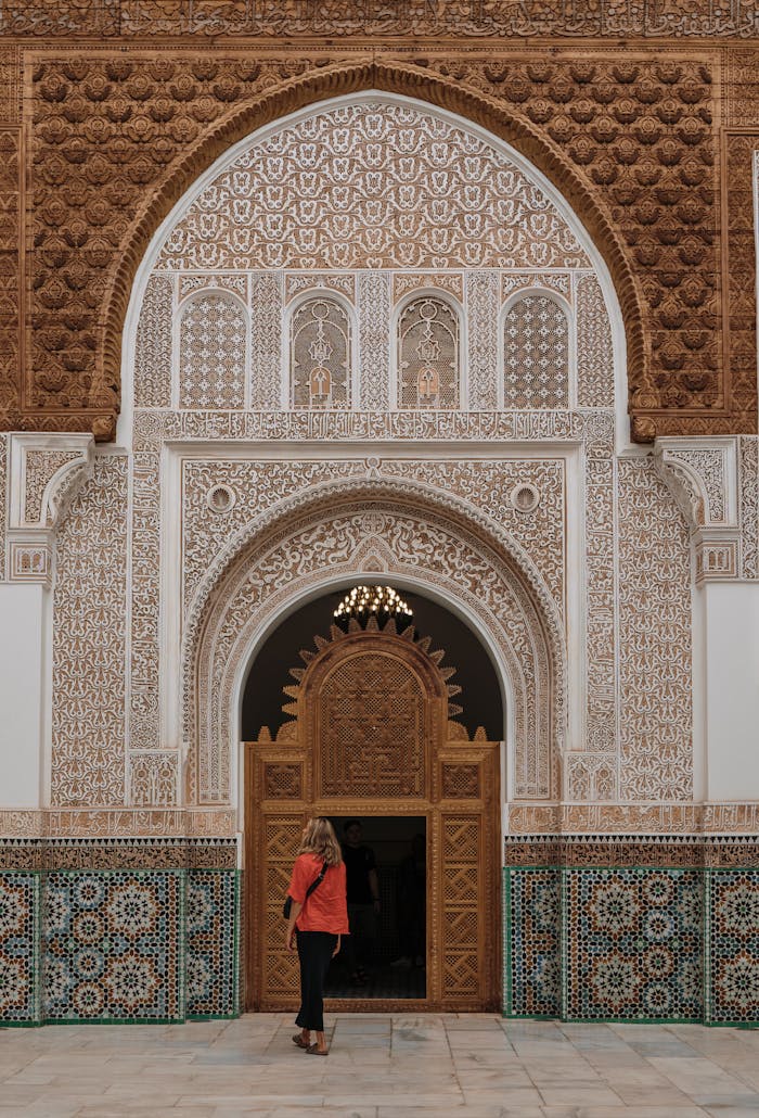 Tourist exploring ornate Moroccan architectural facade in Marrakesh