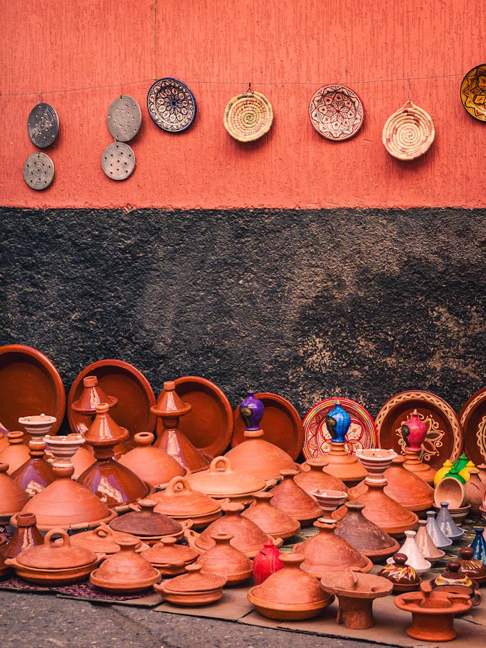 Colorful Moroccan pottery displayed against a vibrant wall in Morocco, showcasing traditional craftsmanship.