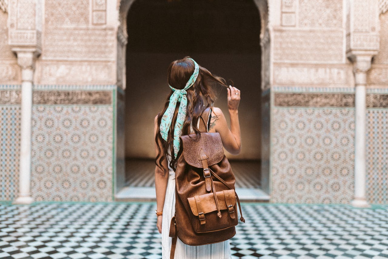 A woman in Marrakesh exploring the medina with a leather backpack, capturing the spirit of travel and adventure.